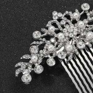 Vista macro di pettine per capelli in argento con perle bianche e strass brillanti