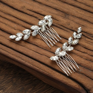 Silver bridal hair combs set with marquise cut crystals on a rustic wood background