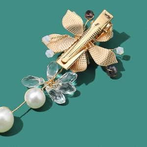 Vue macro montrant la structure arrière et le perlage complexe d'une pince à cheveux dorée