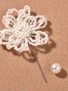Primer plano del broche de flor de perlas blancas hecho a mano con alfiler plateado