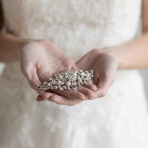 Elegante pettine per capelli da sposa con strass e perle su sfondo di pizzo bianco
