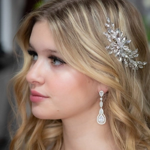 Dettaglio del pettine da sposa e orecchini a goccia con cristalli su capelli biondi
