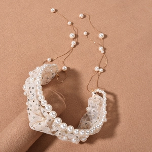 Detail of white pearl and sequin mesh headband with elegant hanging gold chain tassels