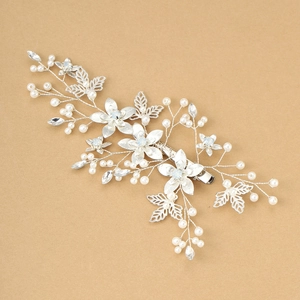 Detail of bridal hair clip with silver leaves, white pearls and blue crystals