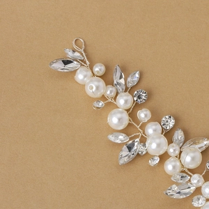 Détail de vigne à cheveux mariée argentée avec strass marquise et perles sur fond brun neutre