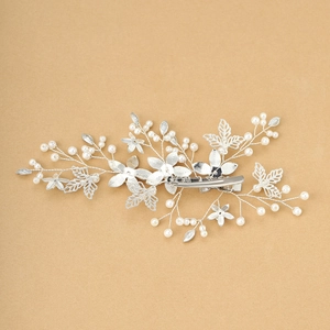 Detailed close-up of a silver bridal hair clip with hollow leaves and crystal pearls