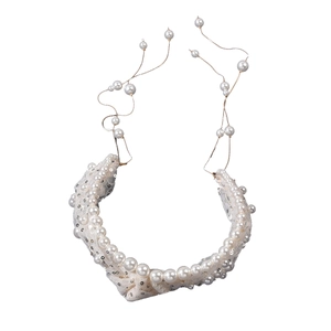 Close-up of bridal white lace headband with pearls, sequins and elegant tassel details