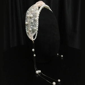 Detail view of pearl headband with pink lace, sequins and long tassel gold chains
