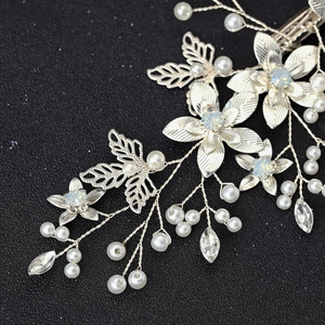 Silver bridal hair clip with opal crystals, pearls, and leaf details on a black background