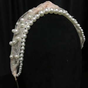 Close-up of vintage bridal headband with pearls, lace and delicate floral sequins
