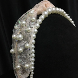 Detail of bridal headband featuring white pearls, pink lace mesh and sparkling sequins