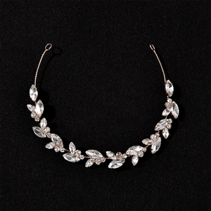 Detailed macro view of rose gold leaf headband with zircon crystals on black background