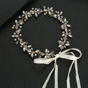 Détail macro du bandeau de mariée montrant les cristaux et le ruban de satin blanc