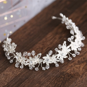 Exquisite bridal headband with silver alloy flowers and crystal beads on wood surface