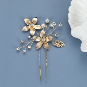 Detail of golden five-petal flower hair pin with pearls, rhinestones and hollow leaf