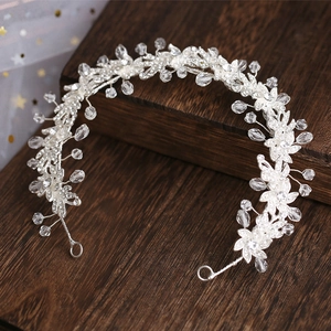 Silver bridal headband with alloy flowers, crystals and pearls on dark wood background
