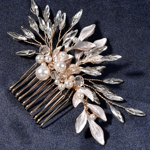 Elegant bridal hair comb with gold wire, white pearls, and rhinestones on blue fabric