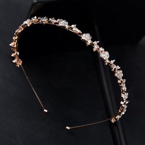 Serre-tête de mariée doré fleurs en strass sur un présentoir à bijoux noir
