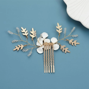 Detailed shot of handmade bridal hair comb with gold leaves and white flowers
