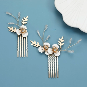 Elegant bridal gold hair comb set with white flowers and crystal leaf details on blue background