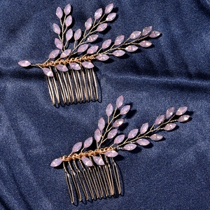 Elegant gold bridal hair combs with pink marquise crystals on a blue fabric background