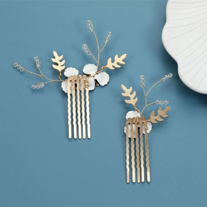 Detail of golden bridal hair combs with white flowers and crystal bead accents