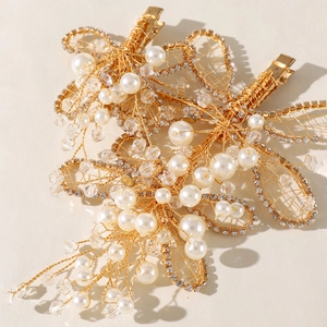 Dettaglio macro di fermagli barocchi dorati con perle e cristalli per acconciature sposa