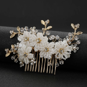 Elegant gold bridal hair comb featuring white flower pearls and sparkling crystals