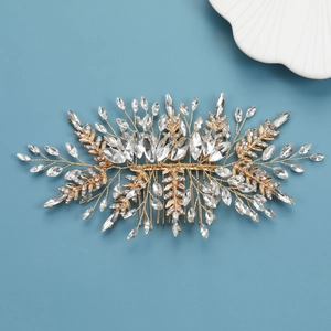 Détail d'un peigne de mariée doré avec cristaux marquise sur fond bleu ciel