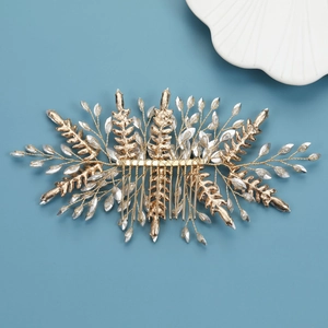 Détail d'un peigne à cheveux doré avec feuilles et cristaux pour coiffures de mariage