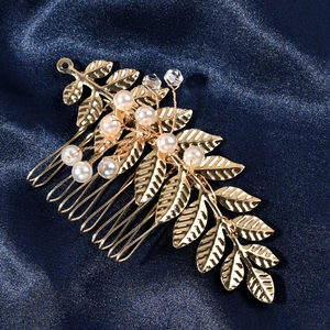 Eleganter goldener Blatt-Haarkamm mit weißen Perlen und Kristallen auf blauem Seidenstoff