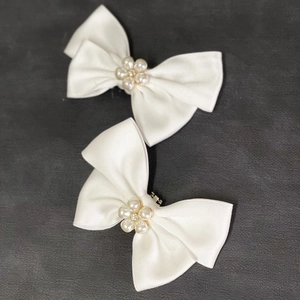 Détail de clips à chaussures en satin blanc avec fleurs en perles et strass