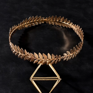 Elegant gold baroque laurel leaf bridal crown tiara on a geometric metal stand