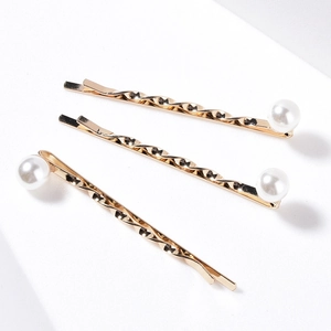 Three-piece set of elegant gold-plated pearl hair pins with spiral texture on white background