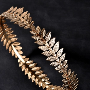 Elegant gold baroque laurel leaf bridal crown crown headpiece on black fabric background