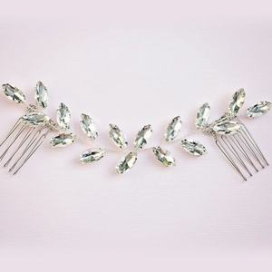 Detail of silver bridal hair comb with marquise cut crystal leaves on soft pink background