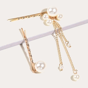 Détail de barrettes dorées élégantes ornées de glands en perles et de fines chaînes en métal