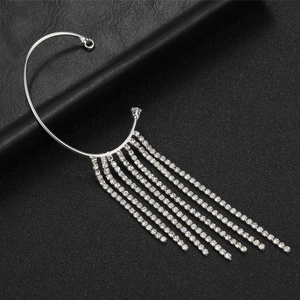 Elegant bridal silver ear cuff with long rhinestone tassels over black leather texture