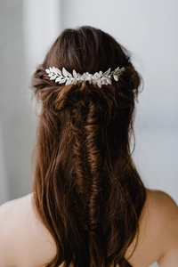Détail d'un peigne à cheveux argenté avec perles baroques dans une coiffure tressée
