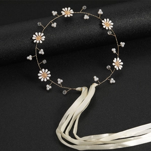Elegant bridal floral headband with white daisies, pearls, and gold wire on black background