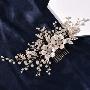 Détail d'un peigne à cheveux floral en or rose avec perles et strass sur soie bleue