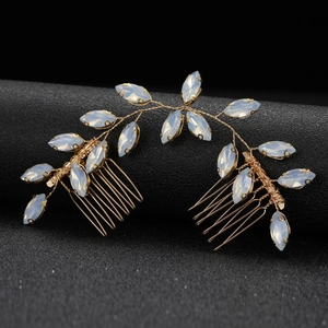 Close-up of golden marquise opal gem hair combs set with leaf-shaped floral design