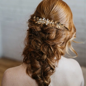 Peigne à cheveux baroque doré avec feuilles et perles sur une coiffure tressée