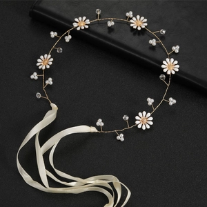 Detailed shot of floral bridal headband with white daisies, pearls, and ivory ribbons