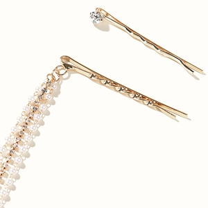 Détail de la pince à cheveux dorée avec franges en perles et strass brillants