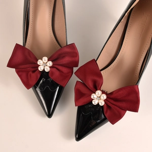Vue détaillée des nœuds en satin bordeaux avec perles sur des talons noirs pointus