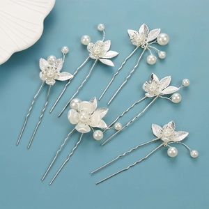 Detail view of 6pcs bridal hair pins set with clover petals and faux pearls on blue surface