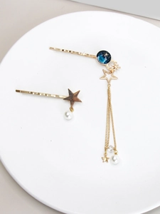 Détails de pinces à cheveux dorées avec planètes bleu marine, perles et glands étoiles