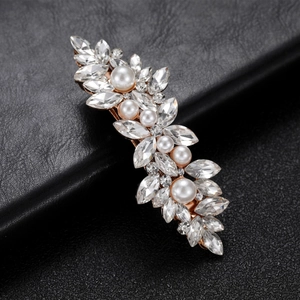 Detail of marquise crystal and pearl hair clip with rose gold leaf design on black leather