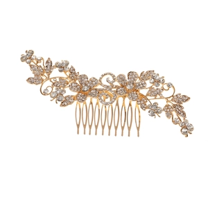 Close-up of golden bridal hair comb featuring floral patterns and sparkling rhinestones